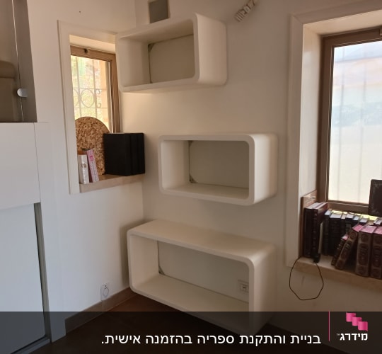 מדפים לבנים מותקנים על קיר ליד חלון